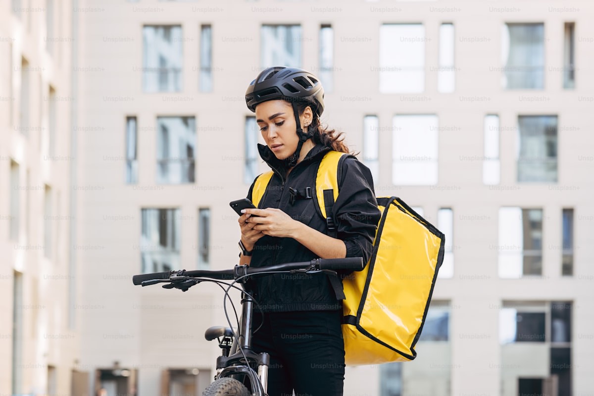 A courier checking the delivery details on their phone