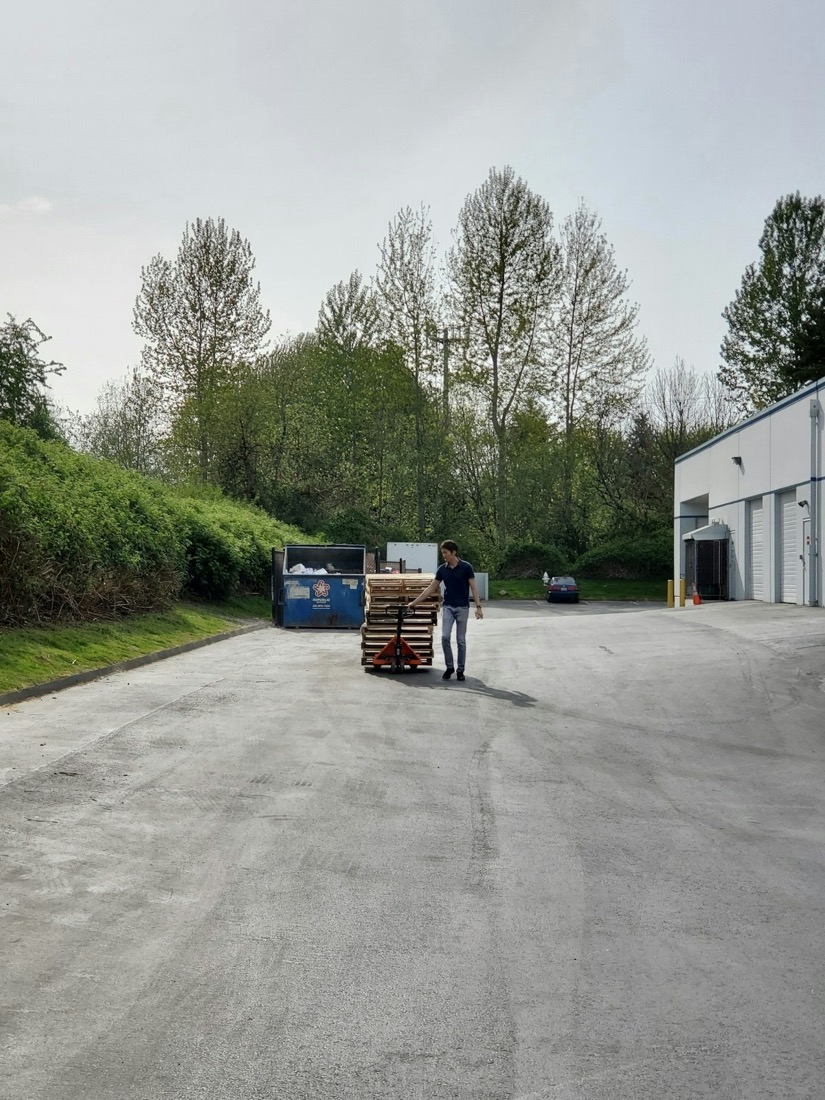 A worker moving pallets at a loading bay
