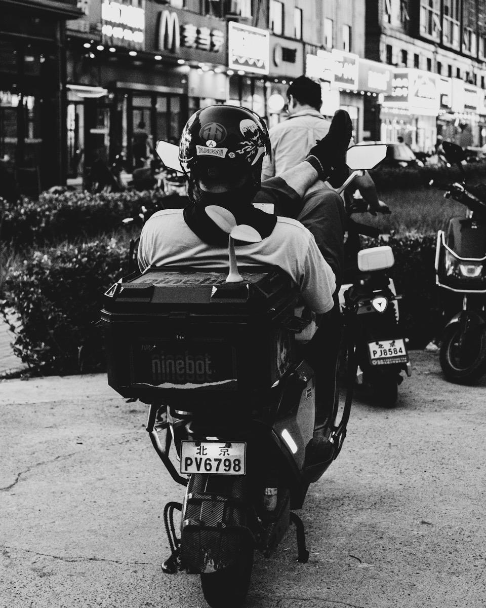 A rider with a delivery box moving through city traffic